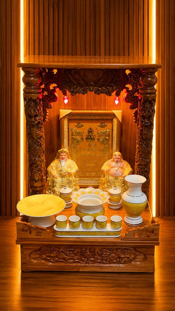 Bàn thờ Thần Tài Thổ Địa chân quỳ chạm nổi, ánh đèn vàng ấm